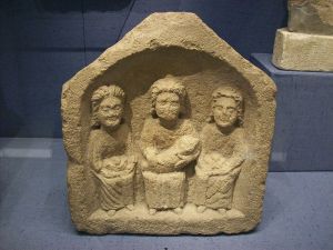 Three goddesses, small Roman relief, Corinium Museum. Photo by Tony Grist (Public domain)