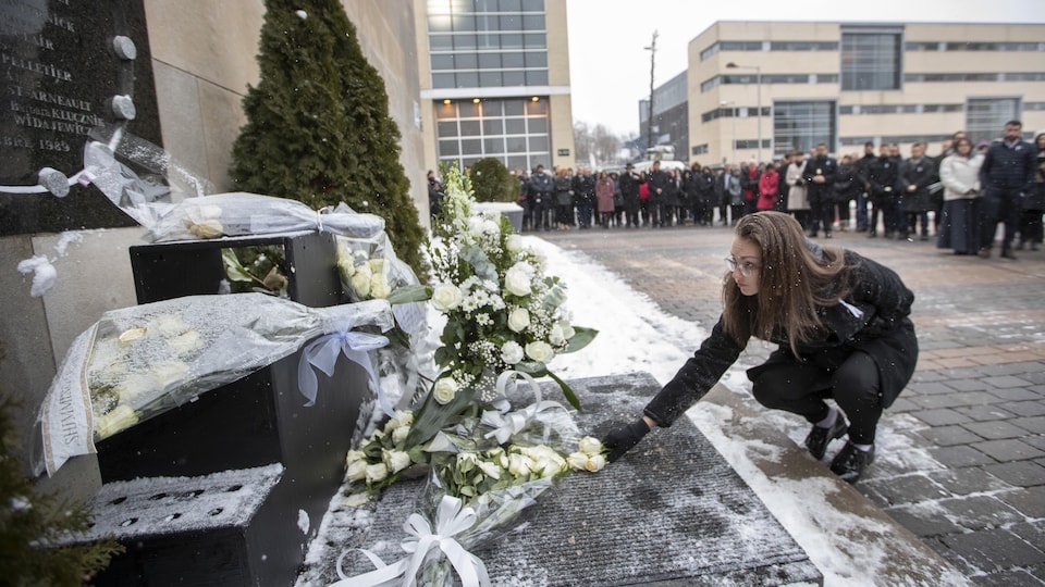 A woman lays roses at the memorial for the 14 women killed in 1989